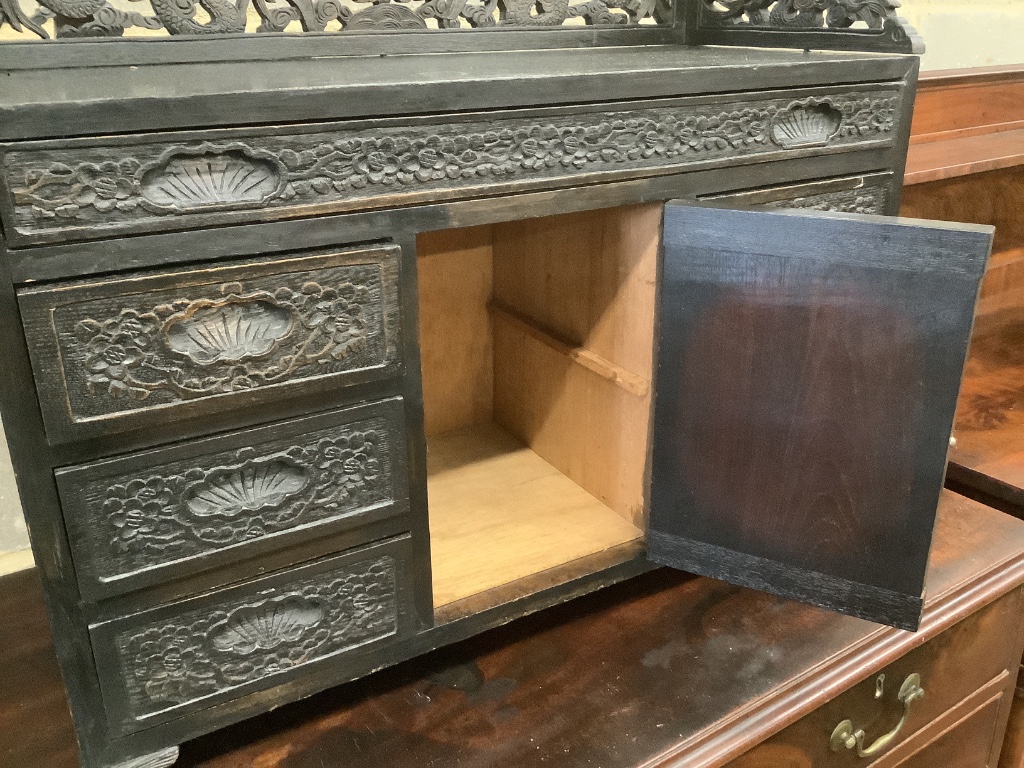 An Edwardian chinoiserie inspired ebonised oak table top cabinet, with cupboard and seven drawers, width 66cm